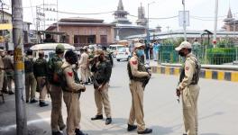 Security personnel stand guard in the closed market on the second anniversary of the abrogation of article 370