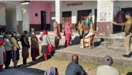 Voters wait in a queue to cast their votes for the Himachal Pradesh Assembly elections, at a polling station in Dharamshala district