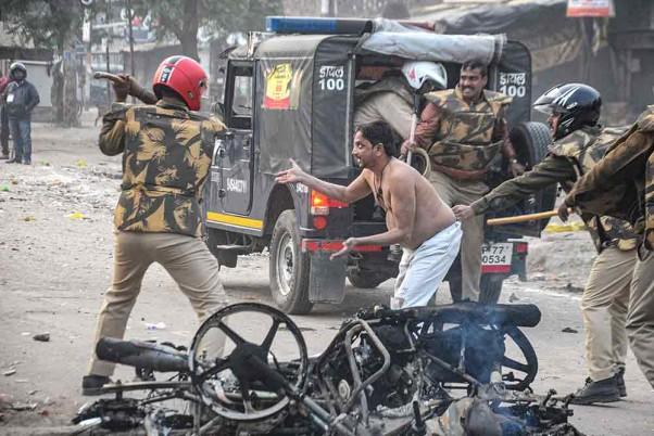 Policeman hits a civilian during a protest against the Citizenship (Amendment) Act