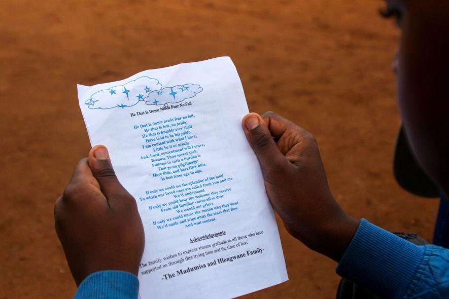 27 February 2021: Amokelang Baloyi reads one of the pamphlets at his brother Mpho Madumisa’s funeral. ‘If only we could know the reason why they went, we’d smile and wipe away the tears that flow, and wait content,’ it says.