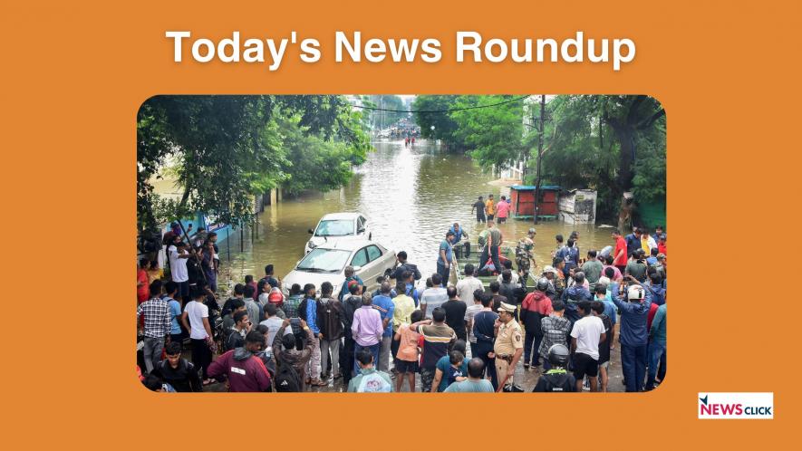 Commuters stand at one side of a road after it was flooded due to heavry rains, in Nagpur, Saturday, Sept. 23, 2023.