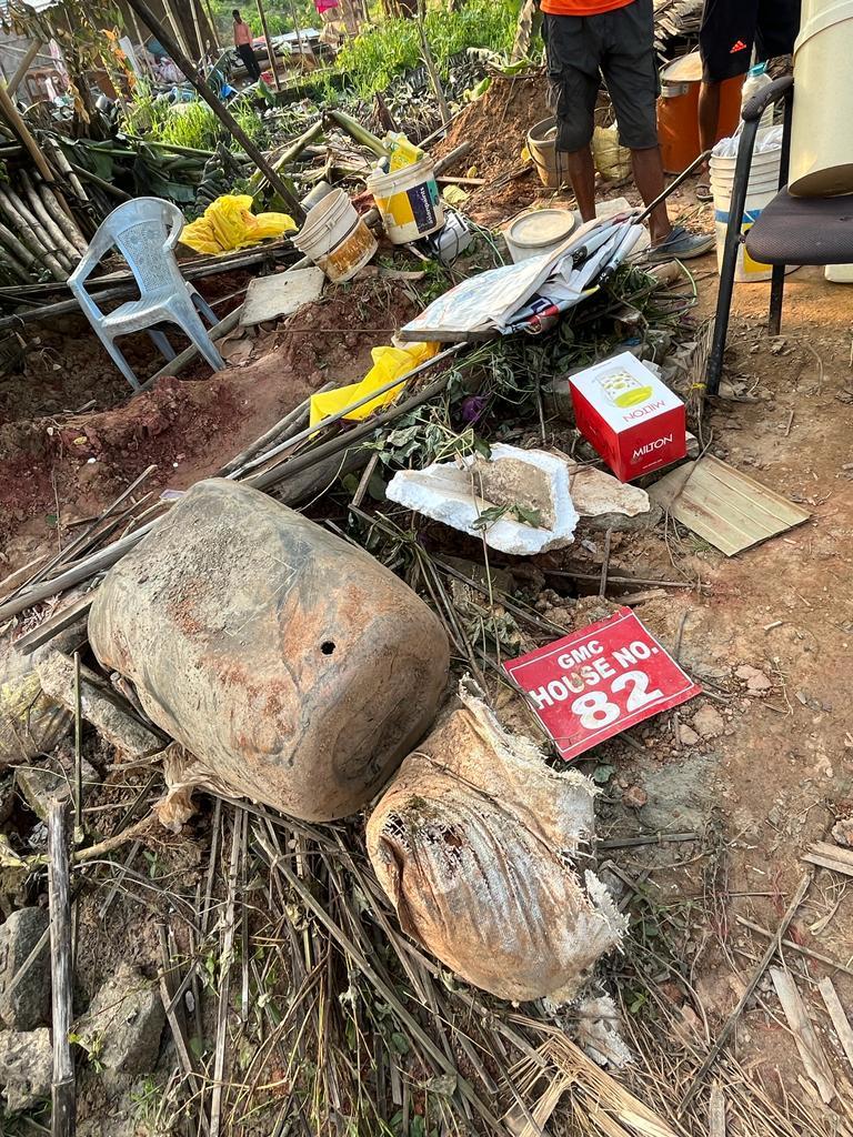 A Guwahati Municipal Corporation house number plate lies amid the ruins of a demolished house.